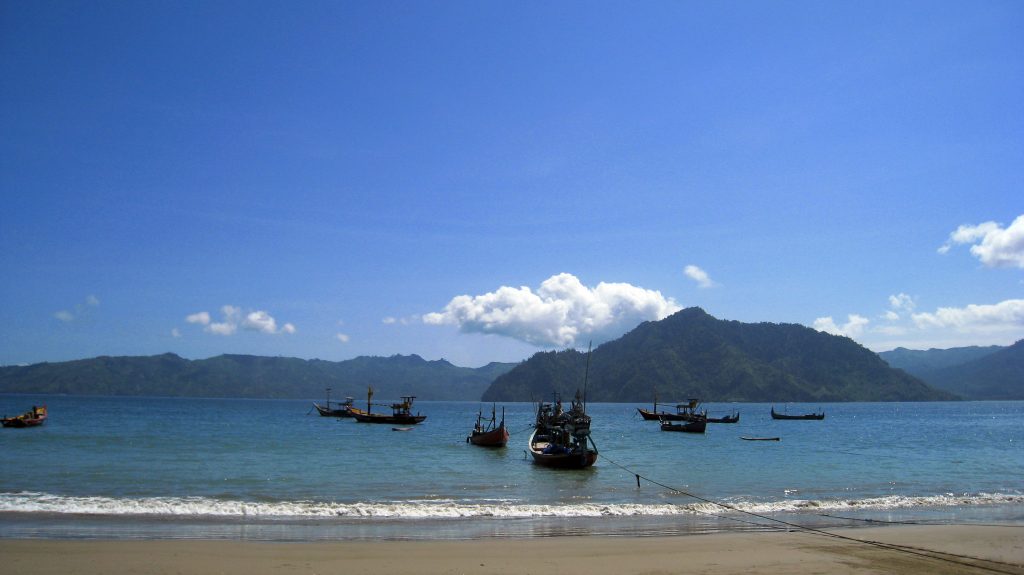 Pantai Prigi Trenggalek dengan pasir kecokelatan dan perbukitan hijau