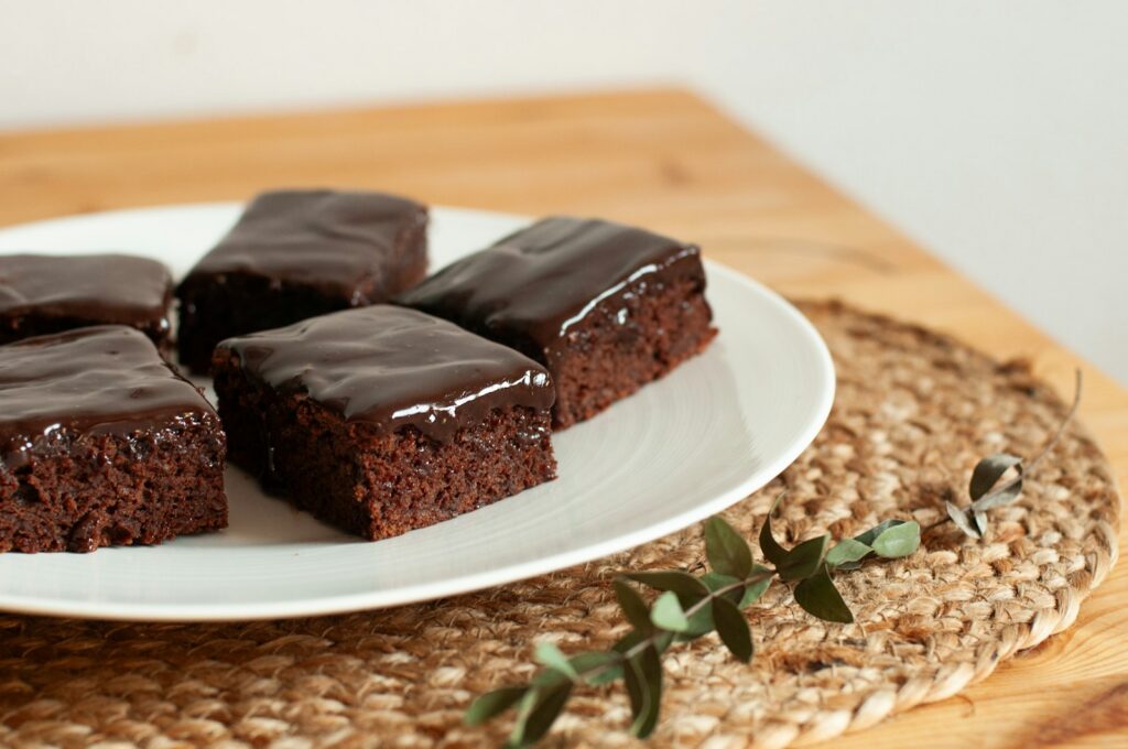 Brownies cokelat dengan lapisan ganache di atas piring putih