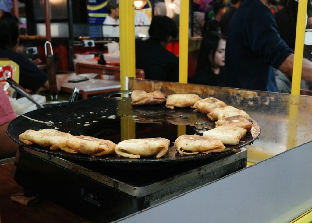 Martabak sedang dimasak di atas wajan pedagang kaki lima