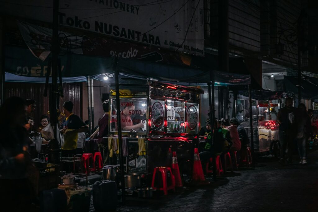 Deretan gerobak kuliner malam dengan kursi plastik merah di Kota Malang