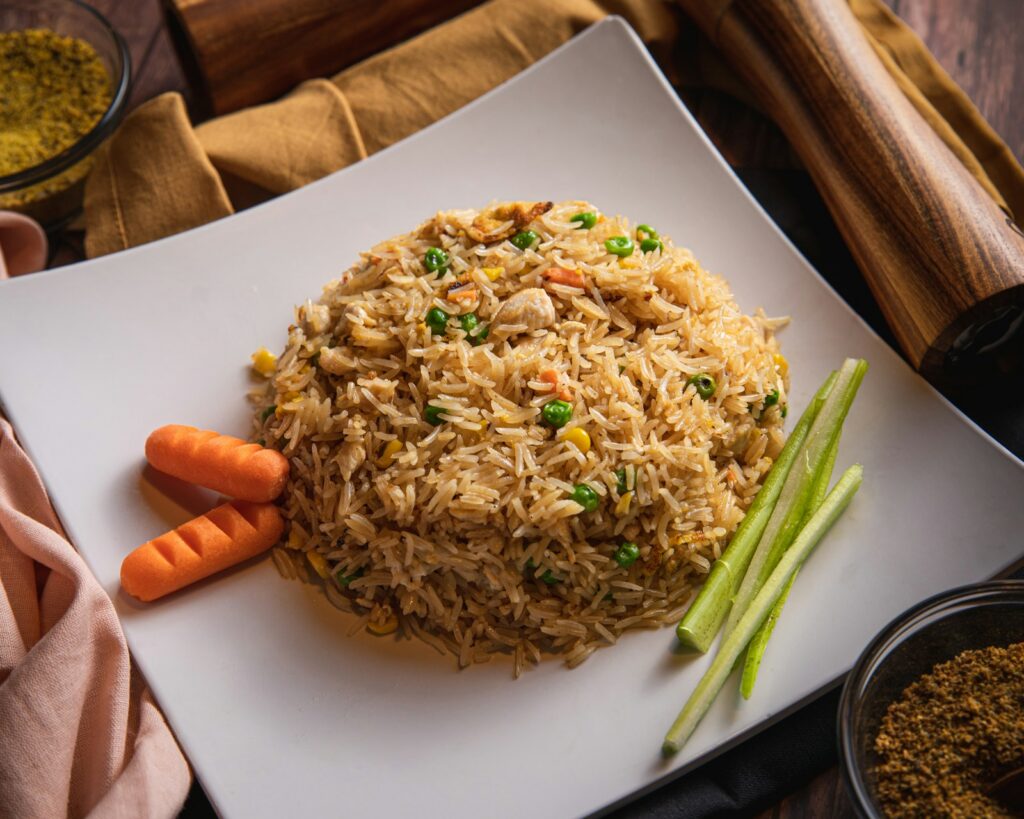 Nasi goreng dengan kacang polong dan wortel di atas piring putih
