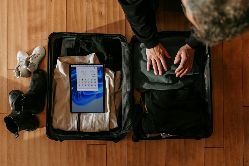 Koper terbuka dengan pakaian yang sedang ditata untuk packing ringkas